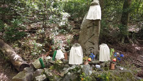 Japanese-Shrine-for-Dead-Spirits-in-the-Forest-Shinto-Religion-Adorned-Stones,-Kyoto-Altar-in-the-Forest