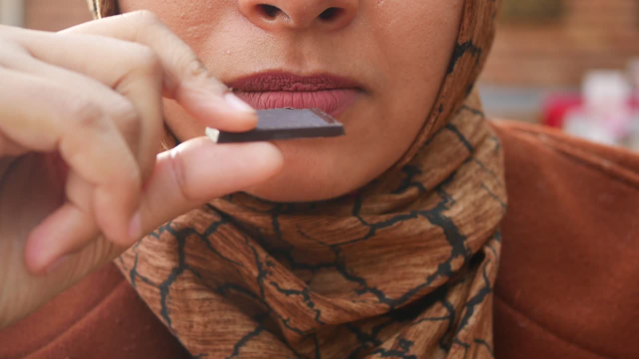 Una mujer comiendo chocolate.