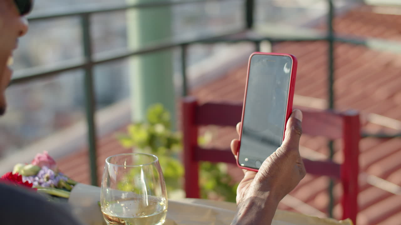 테이블에 앉아 화상 회의를 통해 말하는 남자의 뒷모습