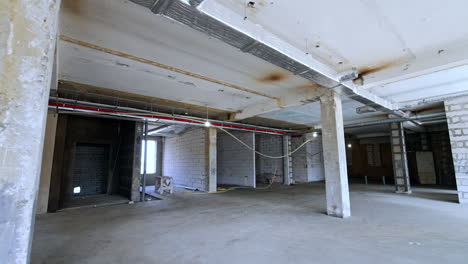 interior with columns and new pipes and electricity system on the ceiling. spacious building under reconstruction.