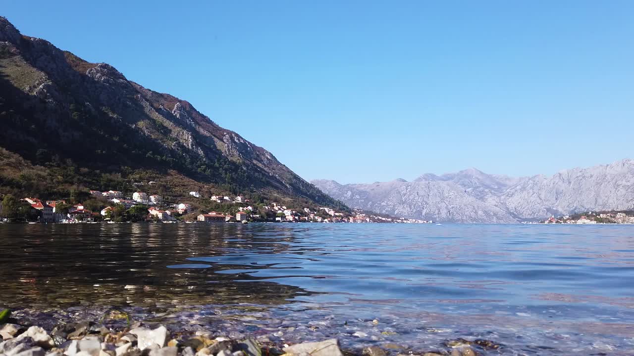 Small and beautiful village in horizon with humongous mountain range in background. Suburbs of Kotor, Montenegro.