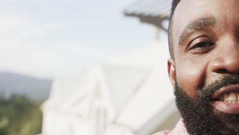 Half-portrait-of-happy-african-american-man-smiling-on-sunny-terrace,-with-copy-space,-slow-motion