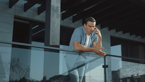 Businessman-talking-mobile-phone-on-terrace.-Angry-man-talking-cellphone.