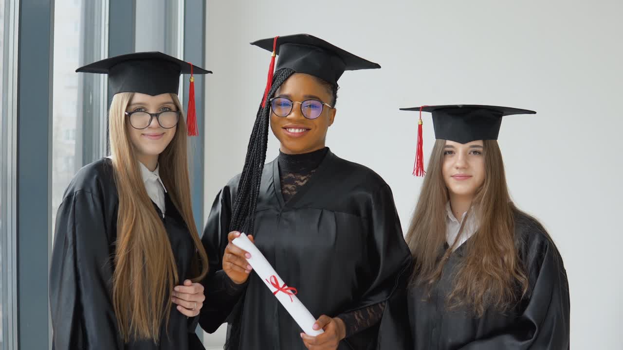 tres estudiantes femeninas de diferentes razas con un diploma en la mano. graduadas universitarias con educación superior