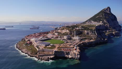 rugby stadium and white mosque at europa point with the lighthouse above the cliffs and in the background ships anchored in bay of algeciras and the upper rock of gibraltar