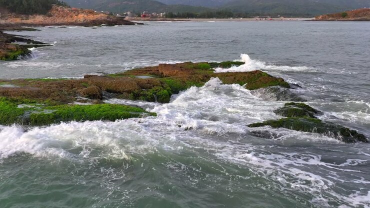 Foto aeree di onde che colpiscono gli scogli e onde che si infrangono