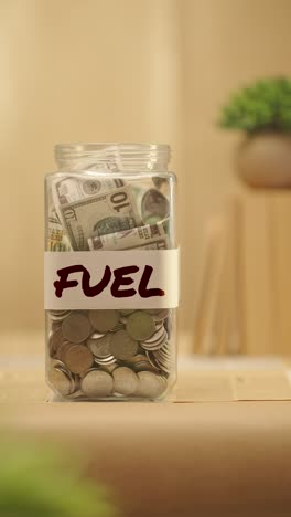 video vertical de una persona ahorrando dinero para el combustible