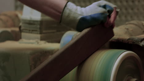 hombre lijando un trozo de madera en el taller - cerrar las manos