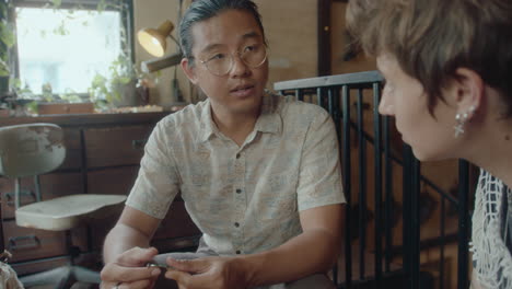 antique store owner telling about old pendant to female customer