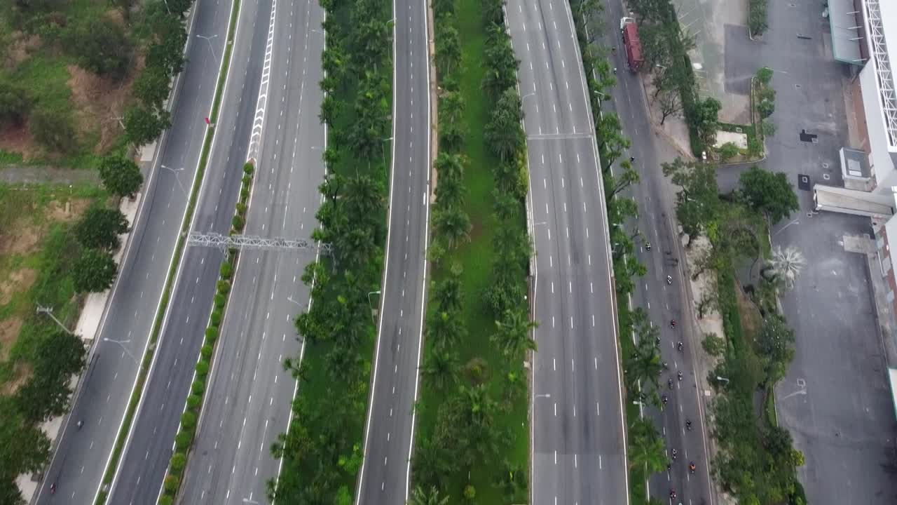 Drone bird's eye view follows mopeds riding in empty streets in vietnam