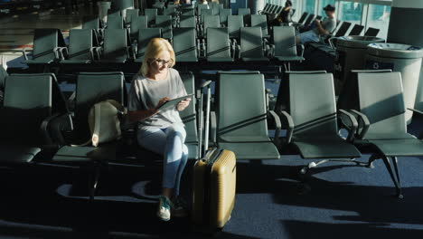 woman uses tablet in airport gate