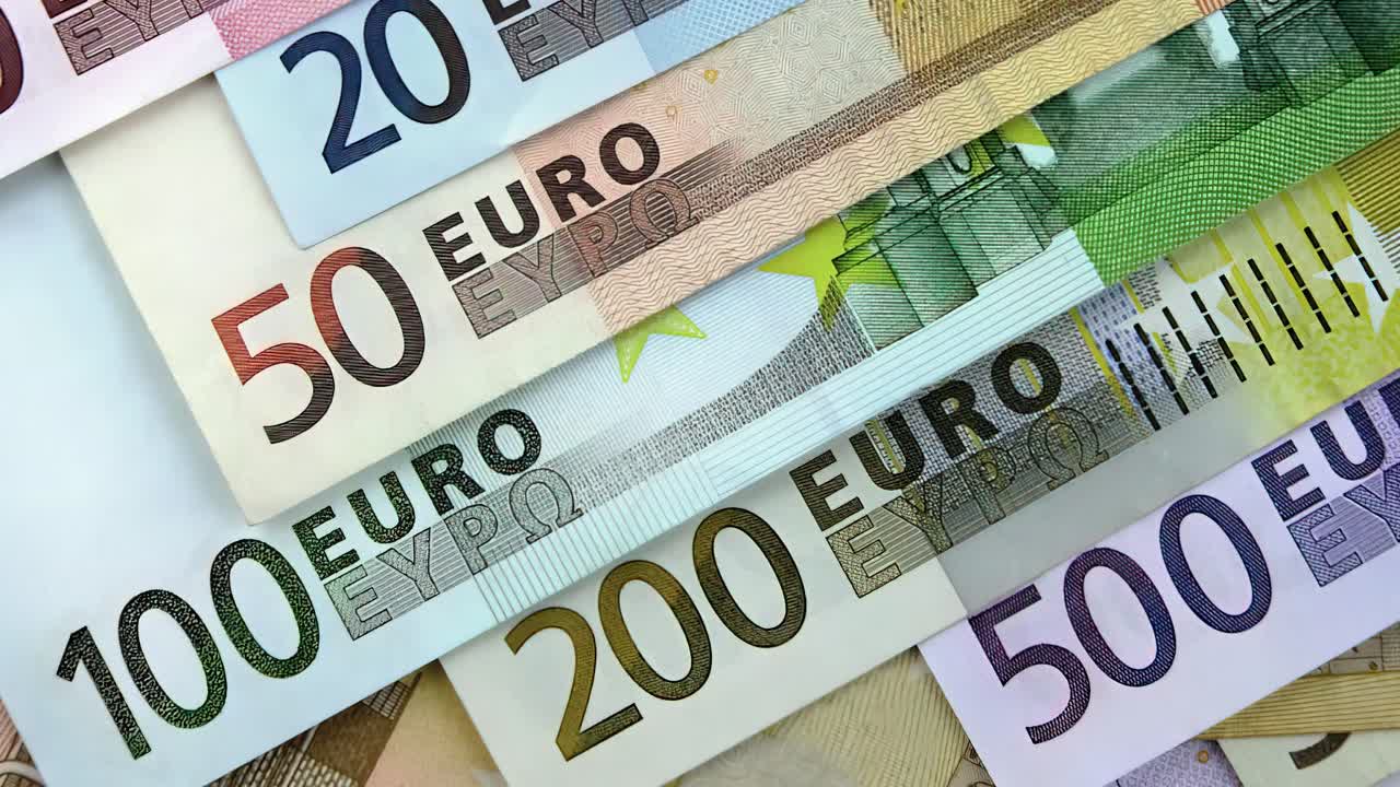 A close-up of counting euro banknotes. Cash money in the background.