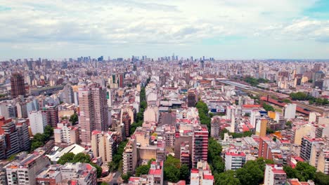 Dolly-En-Vista-Aérea-De-Edificios-Residenciales-En-El-Barrio-De-Almagro-En-Un-Día-Soleado,-El-Horizonte-De-Puerto-Madero-Se-Ve-Al-Fondo,-Argentina