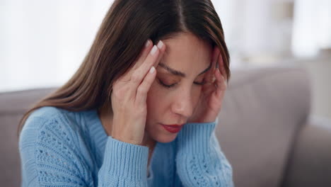 woman holding her head in pain