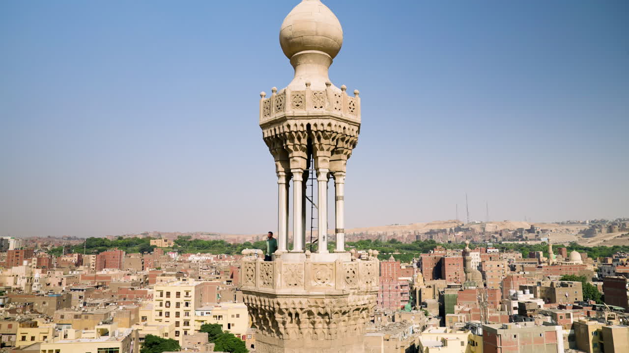 Man At Minaret Tower Of Bab Zuweila, Gate In City Walls Of Historic Cairo In Egypt. wide shot