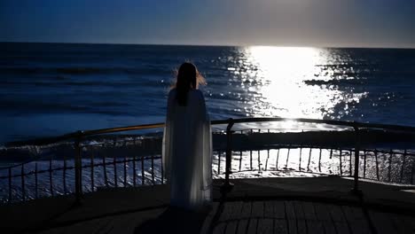 woman in white dress at the beach at sunset/sunrise