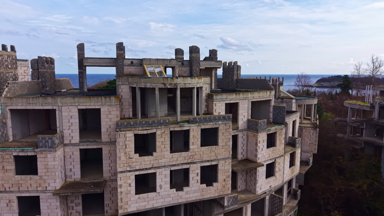 La bellezza decadente rivela i suggestivi resti di un edificio costiero un tempo fiorente sotto un cielo nuvoloso