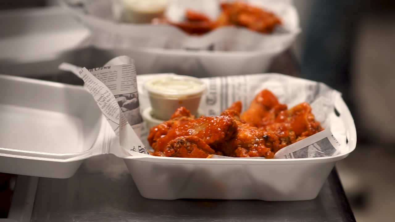Hot Wings in To Go Container with Side of Sauce