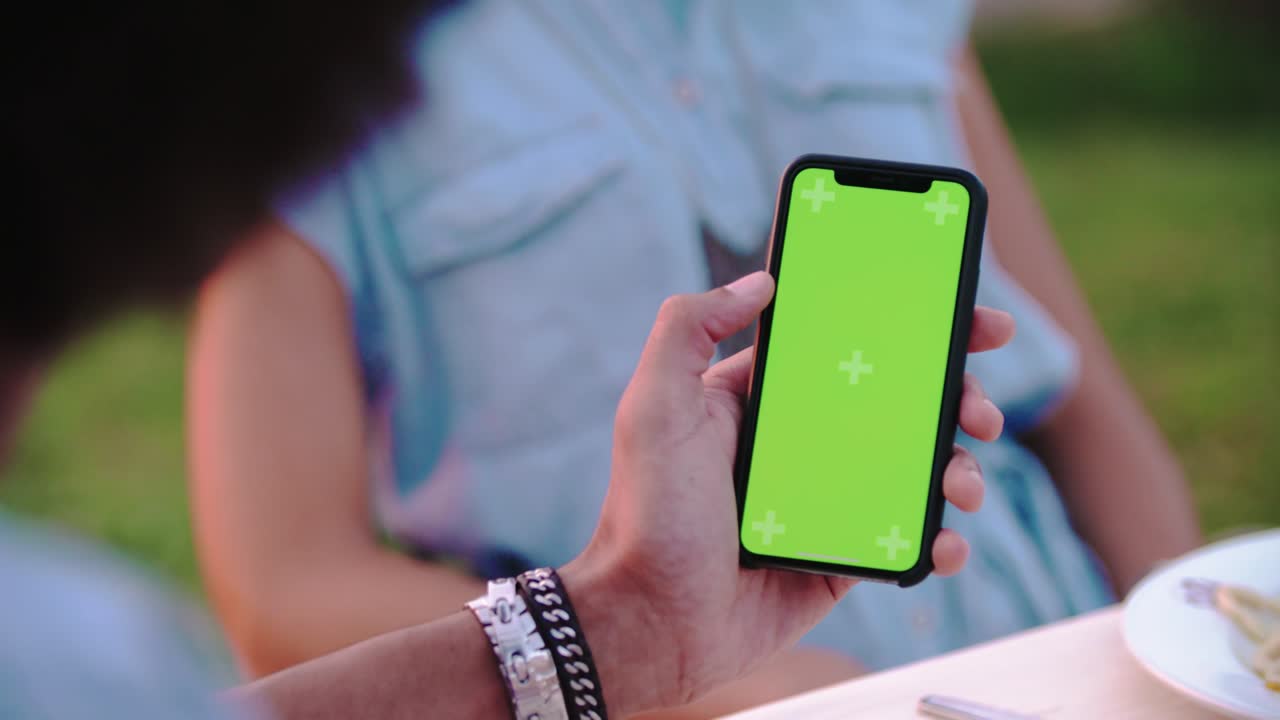 hombre usando un teléfono inteligente de pantalla verde durante una cena romántica al aire libre al atardecer.amigos viaje italiano en umbria.4k cámara lenta