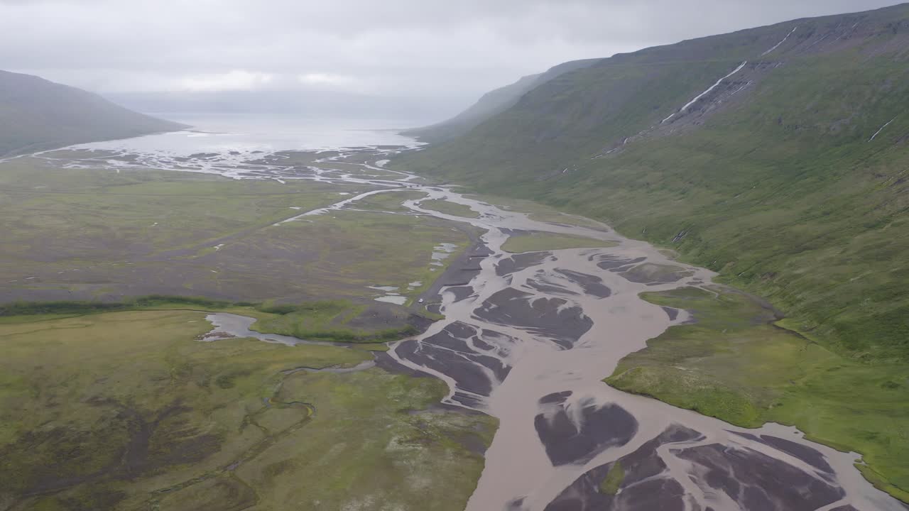 bancos de arena y río glaciar en el paisaje brumoso de kaldalon en los fiordos occidentales, islandia