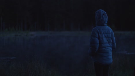 Persona-Viendo-Una-Niebla-Rodando-Sobre-El-Lago-Por-La-Noche,-Atmósfera-Oscura-Y-Malhumorada