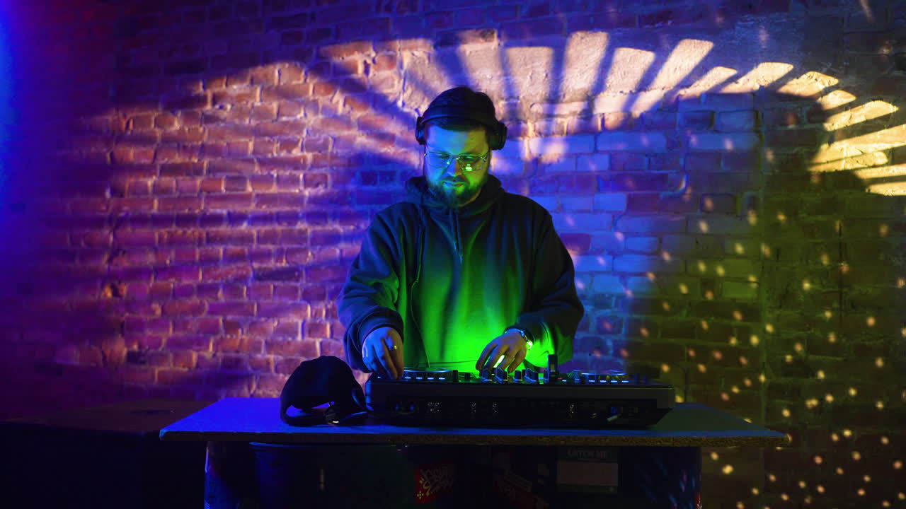 mężczyzna w czarnej czapce grający jako dj na dyskotece