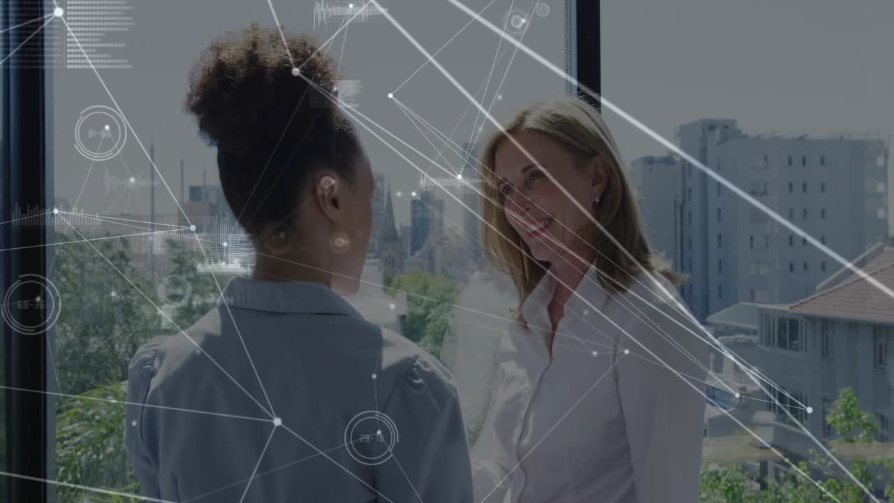 Due donne conversano vicino a un'ampia finestra discutendo di strategia aziendale, con un'interfaccia HUD che visualizza dati di mappatura.