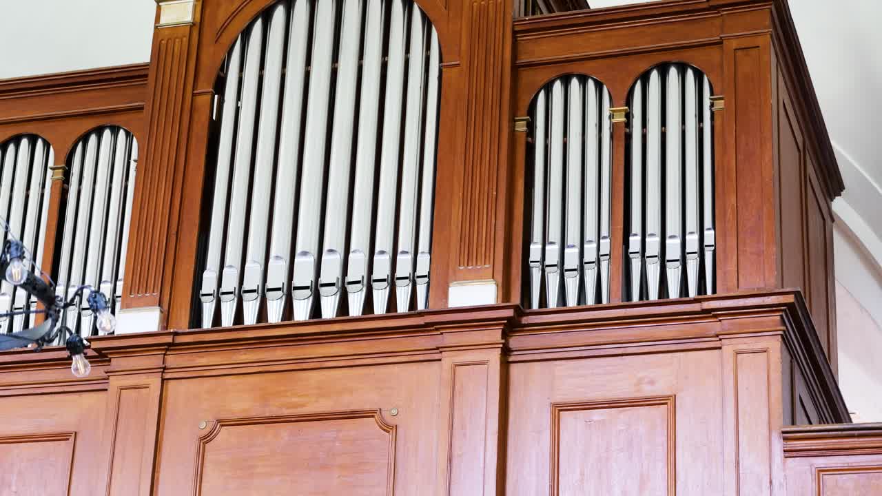Large pipe organ with intricate wooden casing inside a historic reform church in Szalkszentmarton, Hungary