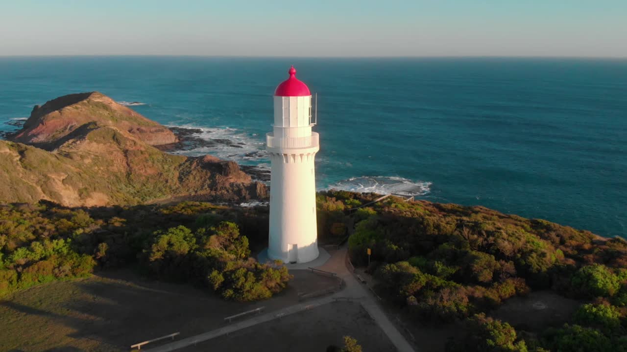drone aerial of lighthouse during golden sunset