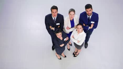 businesspeople standing with arms crossed in office