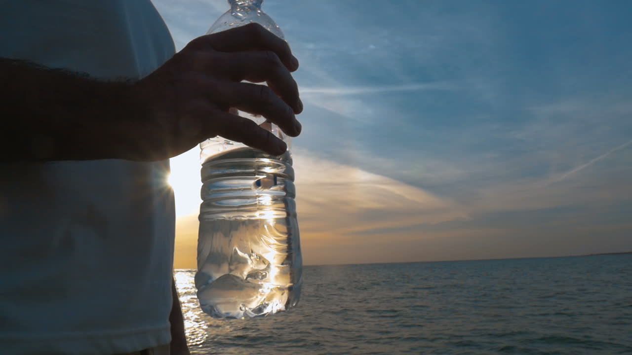 botella de agua en la mano del hombre