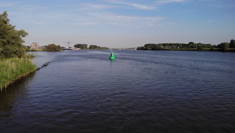 aerial flying over oude mass to floating green buoy