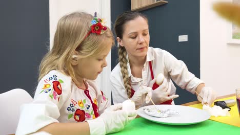 madre e hija decorando huevos de pascua