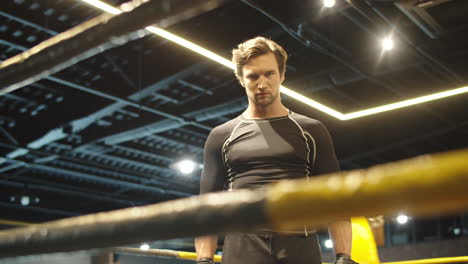 hombre en forma molesto golpeando puños en el ring de boxeo. hombre deportivo preparándose para la pelea