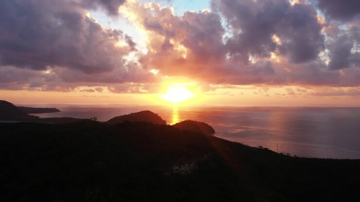 Luce solare arancione che si riflette sul mare insieme alle isole delle Fiji