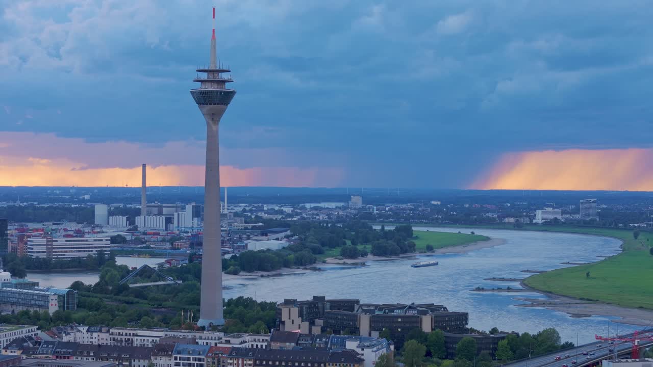 En smuk aftenhimmel indrammer Rheinturm og floden i Düsseldorf.