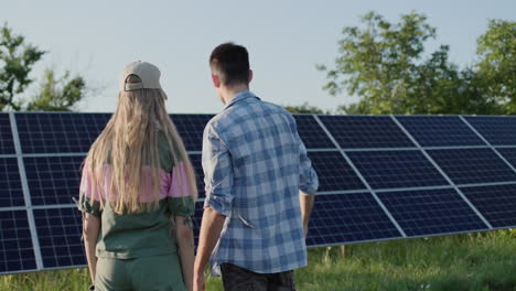 un joven le habla a una adolescente sobre una planta de energía solar