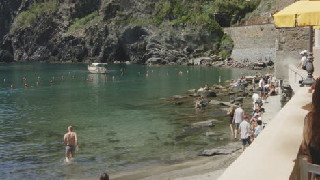 people on the rocky shore of porto di vernazza in the province of la spezia in northern italy. slow motion shot