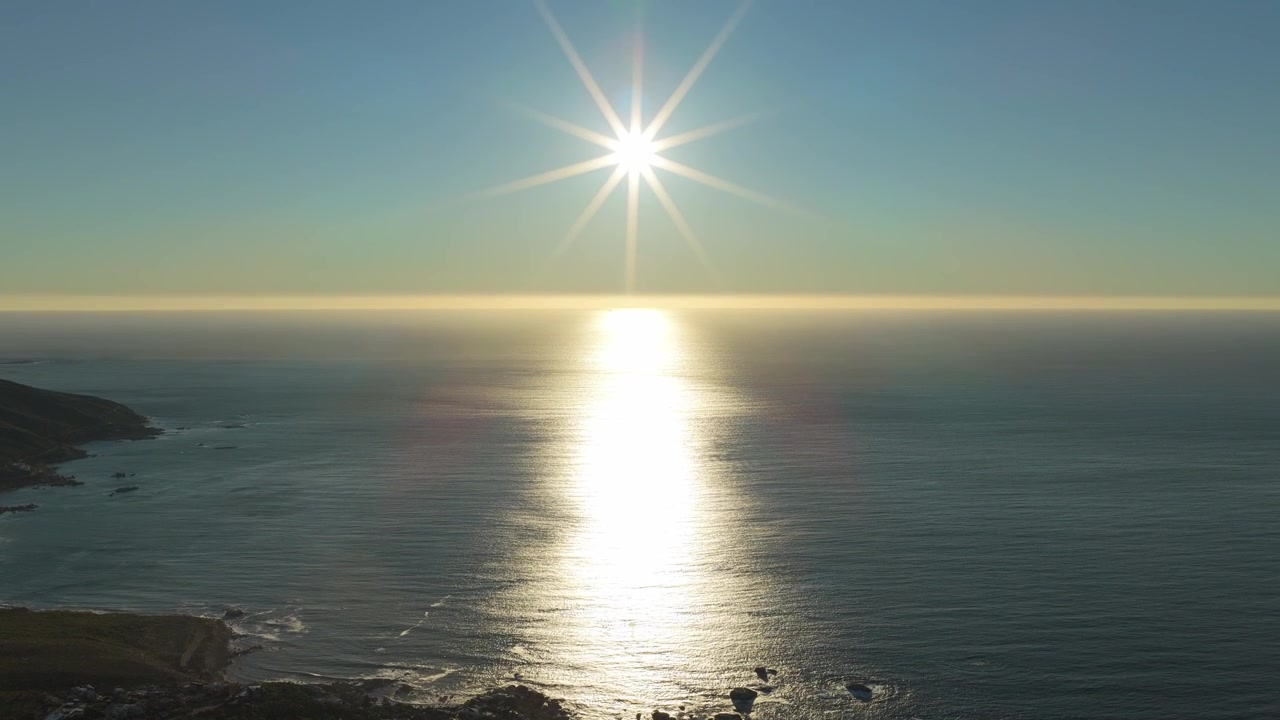 Atardecer en Camps Bay, Ciudad del Cabo. Toma inclinada de dron revelando la bahía.