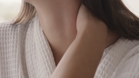 목에 통증이 있는 가운을 입은 알아볼 수 없는 여성의 클로즈업 1