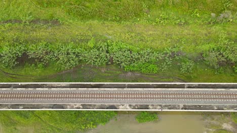 An aerial ascending footage showing the elevated railway on a wetland in Saraburi, Thailand