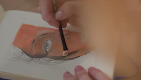 artist hands painting with brush, close up view