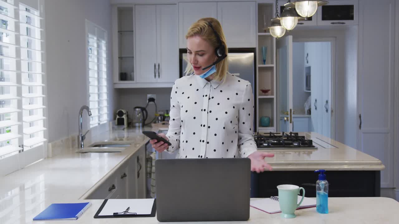 Kvinde med headset taler i smartphone derhjemme