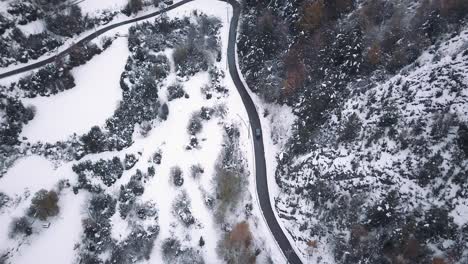 crane drone shot from bird sight to zenital of a volskwagen california driving through the mountain roads of the pyrinees