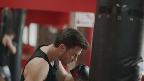 fitness man training box kick in sport club. boxer kicking boxing bag in gloves.