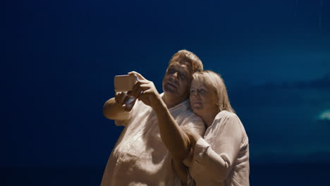 pareja tomando selfies con el teléfono inteligente por la noche