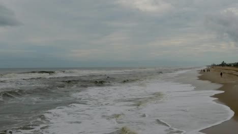 Aerial-shoreline-slow-motion-shot-with-big-waves-on-a-cloudy-day