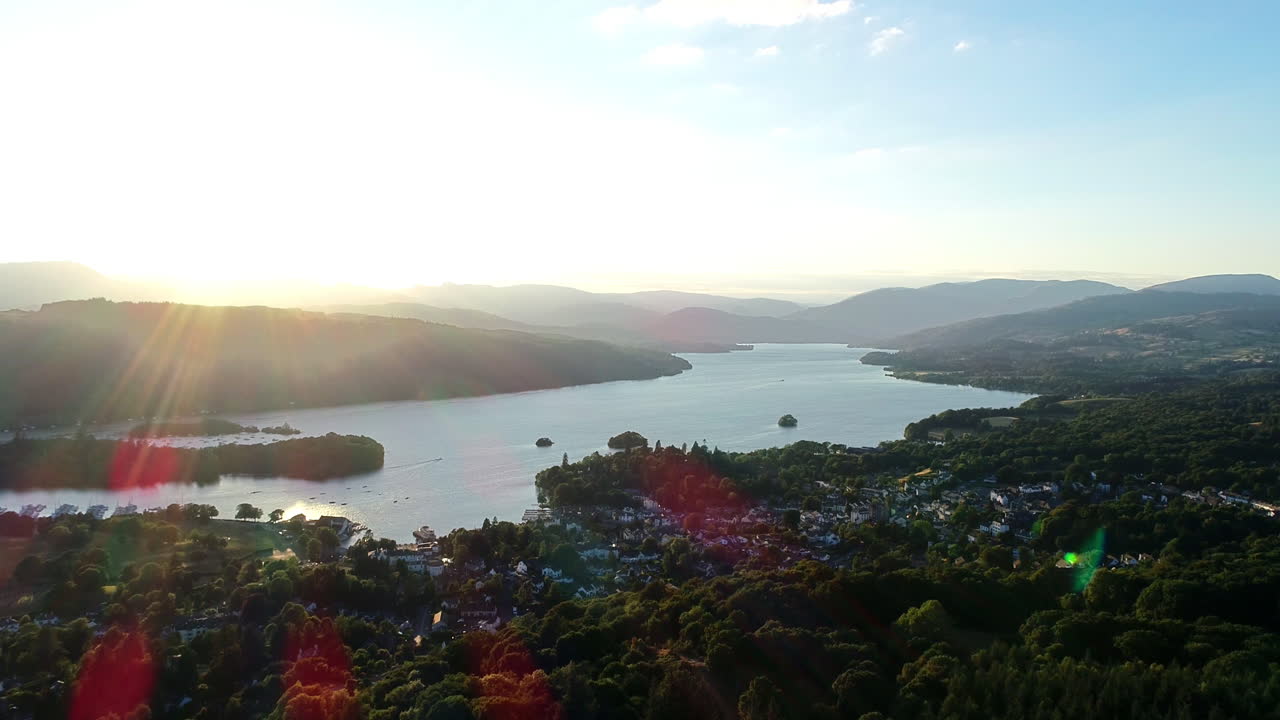 Aerial shot moving back from the houses on the lakeshore and surrounding countryside at Lake Windermere, Lake District, UK
