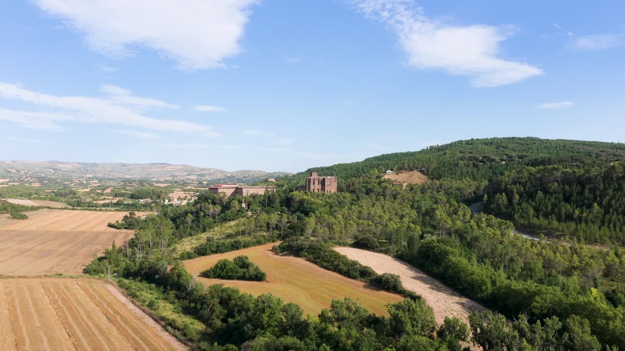 Vista panoramica di un castello circondato da campi e colline