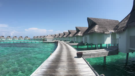 walking on wood walk way with bungalow in ocean sea at maldives